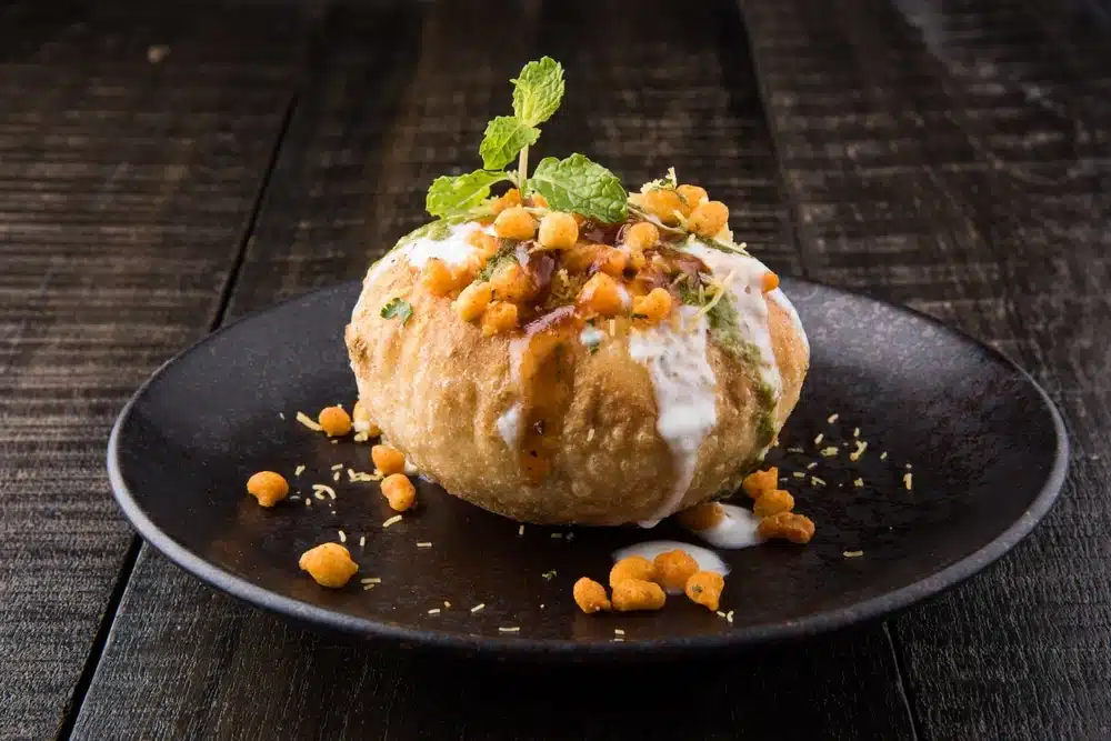 delicious raj kachori topped with yogurt, mint, and crunchy sev