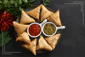 samosas served with red and green chutneys