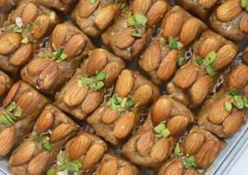 freshly made indian sweets topped with whole almonds and garnished with pistachios